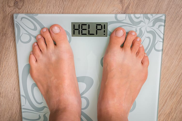 Female feet on personal scales with word HELP! Female feet on personal scales with word HELP! - obesity and diet concept