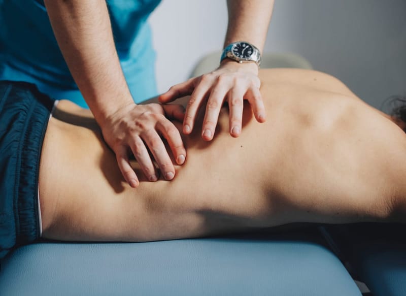 Therapist performing soft tissue manipulation on a patient's back, promoting relaxation and healing through targeted pressure techniques.